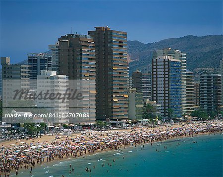 Crowds Of Tourists On The Beach With Apartment Blocks Behind At