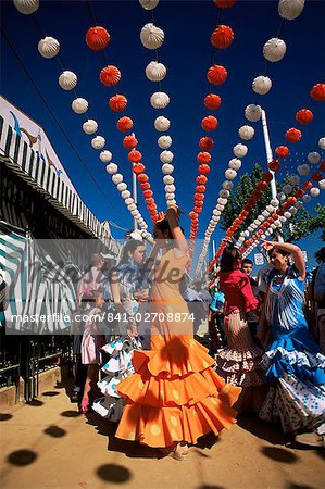 Girls dancing a sevillana beneath colourful lanterns, Feria de Abril (April Fair), Seville, Andalucia (Andalusia), Spain, Europe