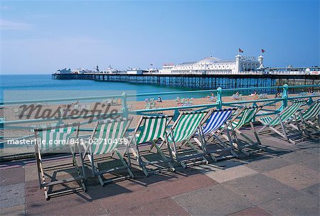Deckchairs above the beach and the Palace Pier at Brighton, Sussex, England, United Kingdom, Europe