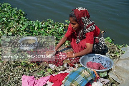 A Bangladeshi woman washing clothes beside the river in Dhaka (Dacca), Bangladesh, Asia