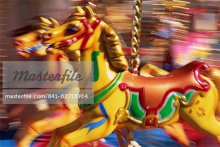 Motion blur of brightly painted merry go round (carousel) horses at speed, Skegness, Lincolnshire, England, United Kingdom, Europe