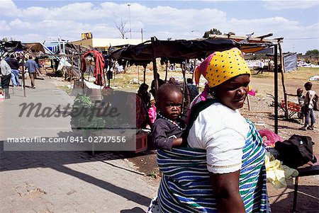 Woman carrying small child on her back, Soweto, Johannesburg, South Africa, Africa