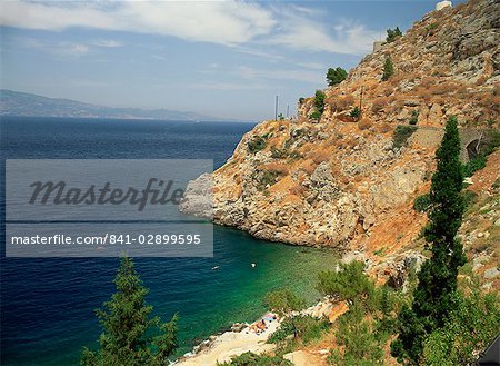 Swimmers in sea below cliffs on Hydra, Argo Saronic Islands, Greek Islands, Greece, Europe