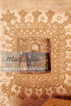 Raised mud reliefs inlaid with mirror on the walls of modern home in traditional tribal Rabari round mud hut, Bunga style, near Ahmedabad, Gujarat state, India, Asia