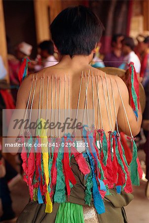Back of a Tibetan man with needles inserted into skin in manhood rites in Qinghai Province, China, Asia