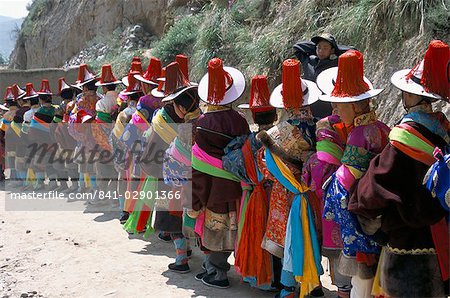 Line of people wearing Tibetan traditional dress, Tongren, Qinghai Province, China, Asia