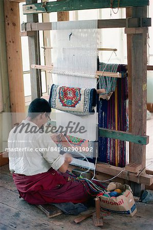 Man working at a loom weaving a carpet in Bhutan, Asia