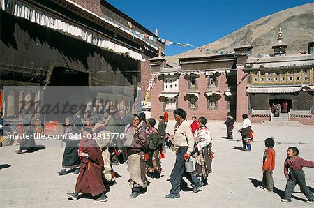 Pilgrims in monastery courtyard,. Sakya, Tibet, China, Asia