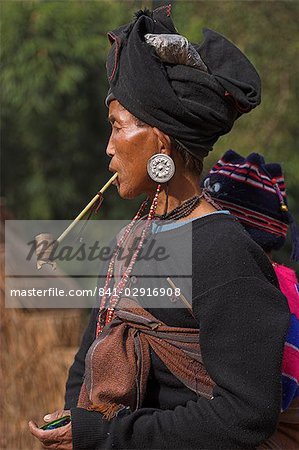 Aku lady with baby on her back smoking wooden pipe, Wan Sai village, Kengtung (Kyaing Tong), Shan state, Myanmar (Burma), Asia