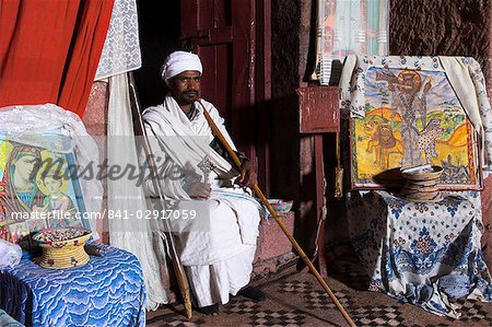 Priest holding cross inside Bet Gabriel-Rufael, Lalibela, Ethiopia, Africa