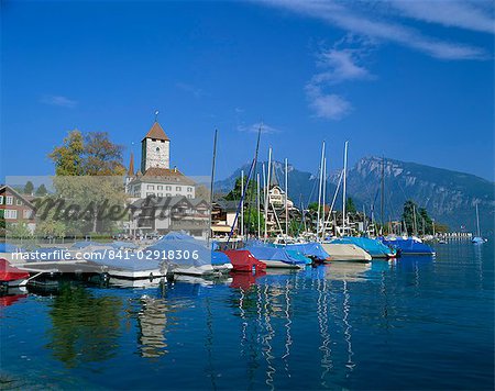 Boats on the water and the town of Spiez on Lake Thunersee in the Bernese Oberland, Switzerland, Europe