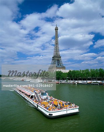 Tourists on bateau mouche on the River Seine with the Eiffel tower in the background, in Paris, France, Europe