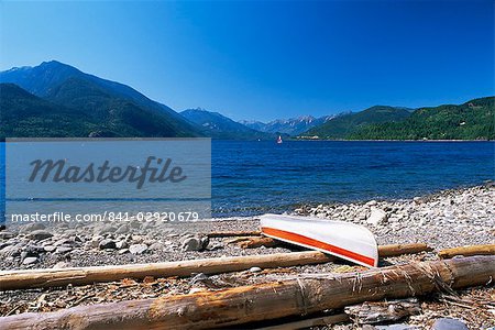 Upturned canoe on the rocky eastern shore of Slocan Lake, New Denver, British Columbia (B.C.), Canada, North America