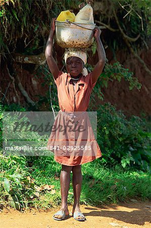 Portrait of a young girl carrying water containers on her head, Haiti, West Indies, Caribbean, Central America