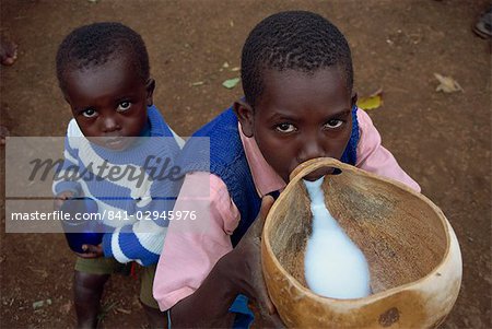 Portrait of young boys drinking goat's milk from gourd, Kenya, East Africa, Africa