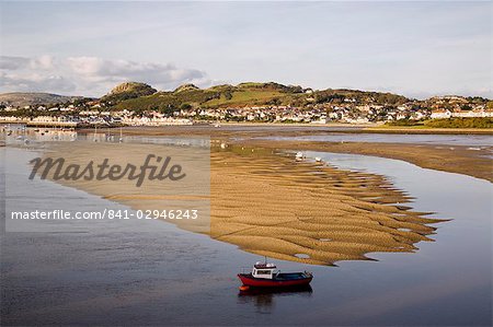 Red boat by exposed rippled sandbank on Conwy River estuary at low tide, with Deganwy beyond, Conwy, Wales, United Kingdom, Europe Red boat by exposed rippled sandbank on Conwy River estuary at low tide, with Deganwy beyond, Conwy, Wales, United Kingdom, Europe