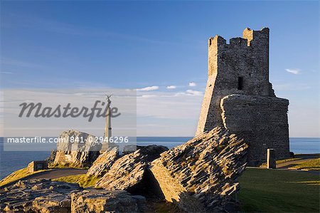 Ruins of 13th century castle and remains of Porth Newydd (New Gate) on Castle Point with War Memorial and sea beyond in low winter light, Aberystwyth, Ceredigion, Dyfed, Wales, United Kingdom, Europe