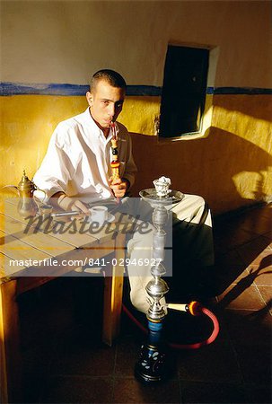 Man smoking a waterpipe in a restaurant, Madaba, Jordan