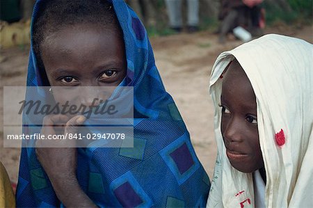 Head and shoulders portrait of two young Gambian children, one looking at the camera, Gambia, West Africa, Africa