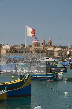 Brightly coloured fishing boats called Luzzus at the fishing village of Marsaxlokk, Malta, Mediterranean, Europe