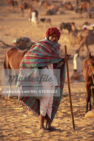 Portrait of an Indian farmer in traditional clothing, wearing turban and shawl, standing and looking at the camera, at Pushkar Camel Fair, Pushkar, Rajasthan, India, Asia