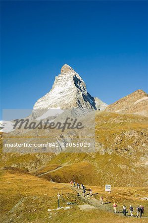 Line of hikers walking on trail near the Matterhorn, 4477m, Zermatt Alpine Resort, Valais, Switzerland, Europe