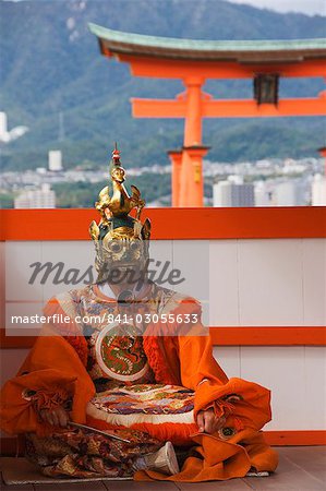 A Wedding Ceremony Dance Performer in front of the Floating Torii Gate at Itsukushima Shrine, founded in 593, UNESCO World Heritage Site, Miyajima Island, Hiroshima prefecture, Honshu Island, Japan, Asia