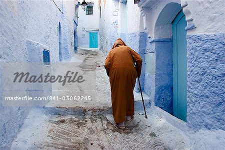 Old man walking in a typical street in Chefchaouen, Rif mountains region, Morocco, North Africa, Africa