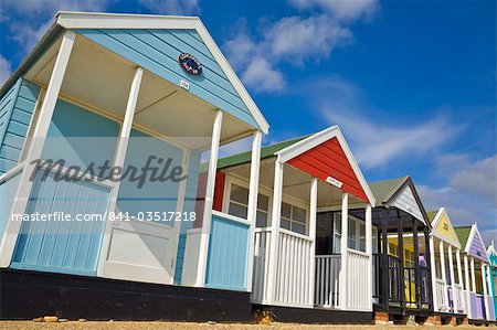 Brightly painted beach huts in the afternoon sunshine, on the seafront promenade, Southwold, Suffolk, England, United Kingdom, Europe