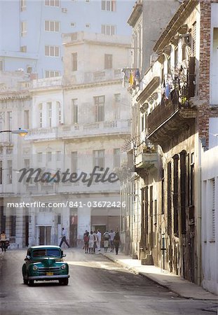 Old American car driving along quiet street in Havana Centro, Havana, Cuba, West Indies, Caribbean, Central America