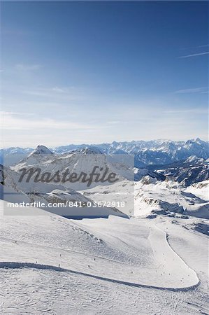 Skiers skiing on a ski run, mountain scenery in Cervinia ski resort, Cervinia, Valle d'Aosta, Italian Alps, Italy, Europe