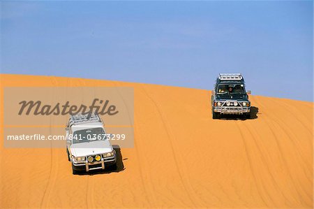Jeeps on sand dune, Akakus, Sahara desert, Fezzan, Libya, North Africa. Africa Jeeps on sand dune, Akakus, Sahara desert, Fezzan, Libya, North Africa. Africa