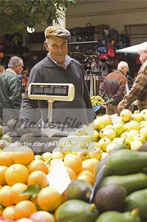 A fruit stall holder works at the Mercado des Lavradores in central Funchal, Madeira, Portugal, Europe A fruit stall holder works at the Mercado des Lavradores in central Funchal, Madeira, Portugal, Europe
