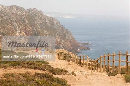 People walk along cliffs overlooking the Atlantic Ocean at Europe's most westerly point at Cabo da Roca, Portugal, Europe