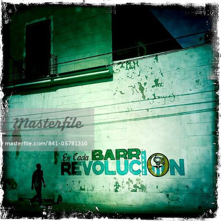 Mural celebrating the Revolution with lone figure walking by, Cienfuegos, Cuba, West Indies, Caribbean, Central America