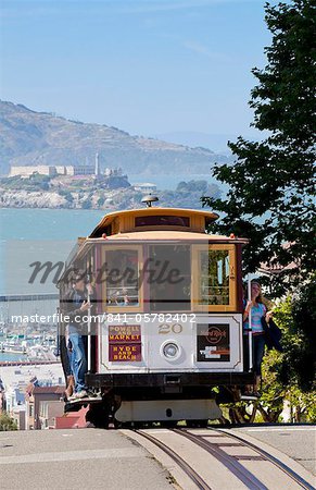 One of the famous cable cars on the Powell-Hyde track, with the island prison of Alcatraz in the background, San Francisco, California, United States of America, North America