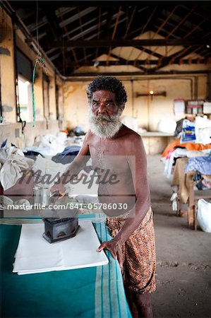 Man ironing in laundry, Cochin, Kerala, India, Asia