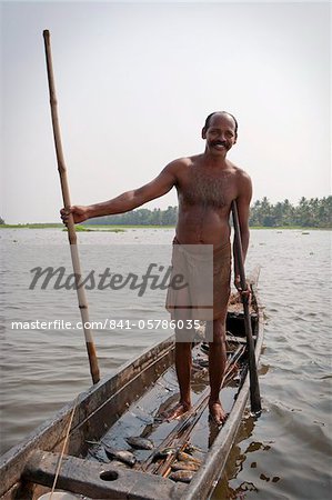 Fisherman standing in boat with fish, Kerala, India, Asia - Stock