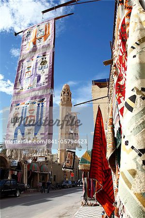Main street with mosque and carpet shop display, Tozeur, Tunisia, North Africa, Africa