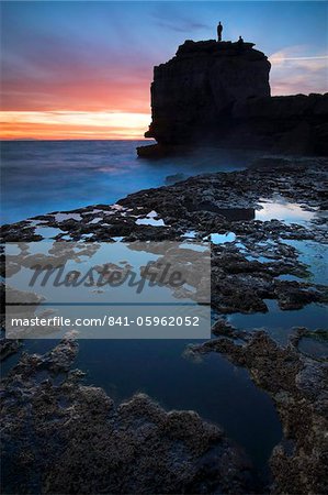 A man stands atop Pulpit Rock watching the sun setting, Portland, Jurassic Coast, UNESCO World Heritage Site, Dorset, England, United Kingdom, Europe