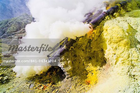 Toxic sulphur fumes escaping from the ceramic pipes at Kawah Ijen, Java, Indonesia, Southeast Asia, Asia