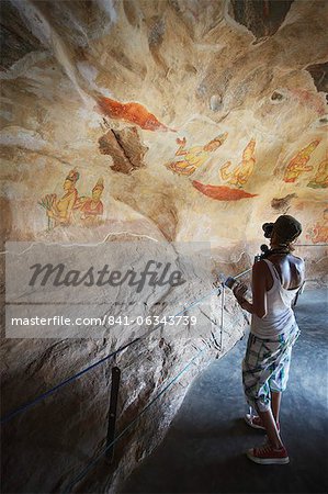 Tourist taking photos of ancient frescoes, Sigiriya, UNESCO World Heritage Site, North Central Province, Sri Lanka, Asia