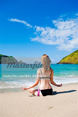 Woman meditating at Mawun Beach, South Lombok, Indonesia, Southeast Asia, Asia