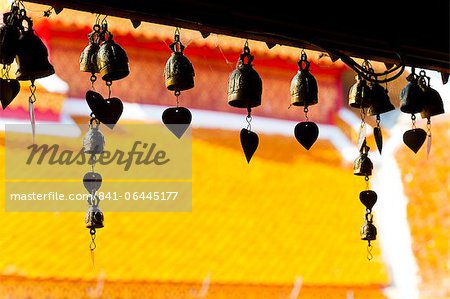 Close up of prayer bells, silhouetted against the colourful roof at Wat Doi Suthep, Chiang Mai, Thailand, Southeast Asia, Asia