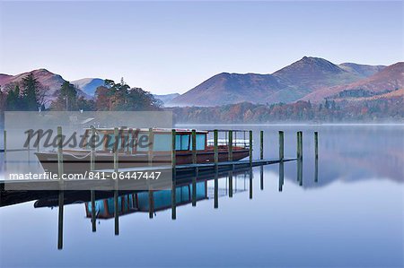 Pleasure boat moored on a placid Derwent Water on a misty and frosty morning, Keswick, Lake District, Cumbria, England, United Kingdom, Europe