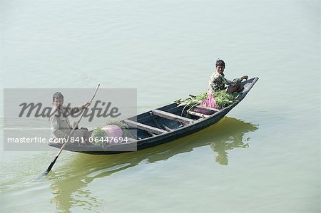 Village men punting a wooden boat along the River Hugli (River Hooghly), carrying bundles of alfalfa to market, near Kolkata, West Bengal, India, Asia