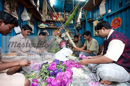 Mala makers (garland makers) at work in Kolkata's morning flower market, Howrah, Kolkata, West Bengal, India, Asia