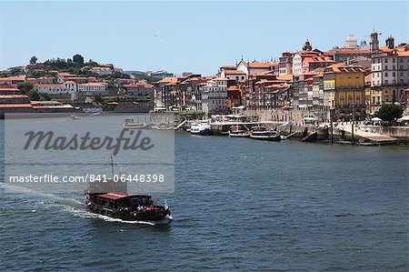 A boat cruises on the River Douro, past the Ribeira District, UNESCO World Heritage Site, Porto, Douro, Portugal, Europe