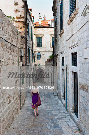 Dubrovnik Old Town, a tourist walking along a narrow side street, Dubrovnik, Croatia, Europe