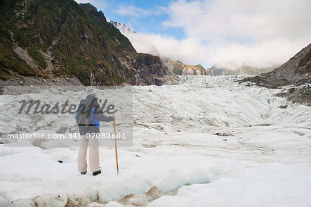 Female tourist walking on Fox Glacier, Westland National Park, UNESCO World Heritage Site, South Island, New Zealand, Pacific